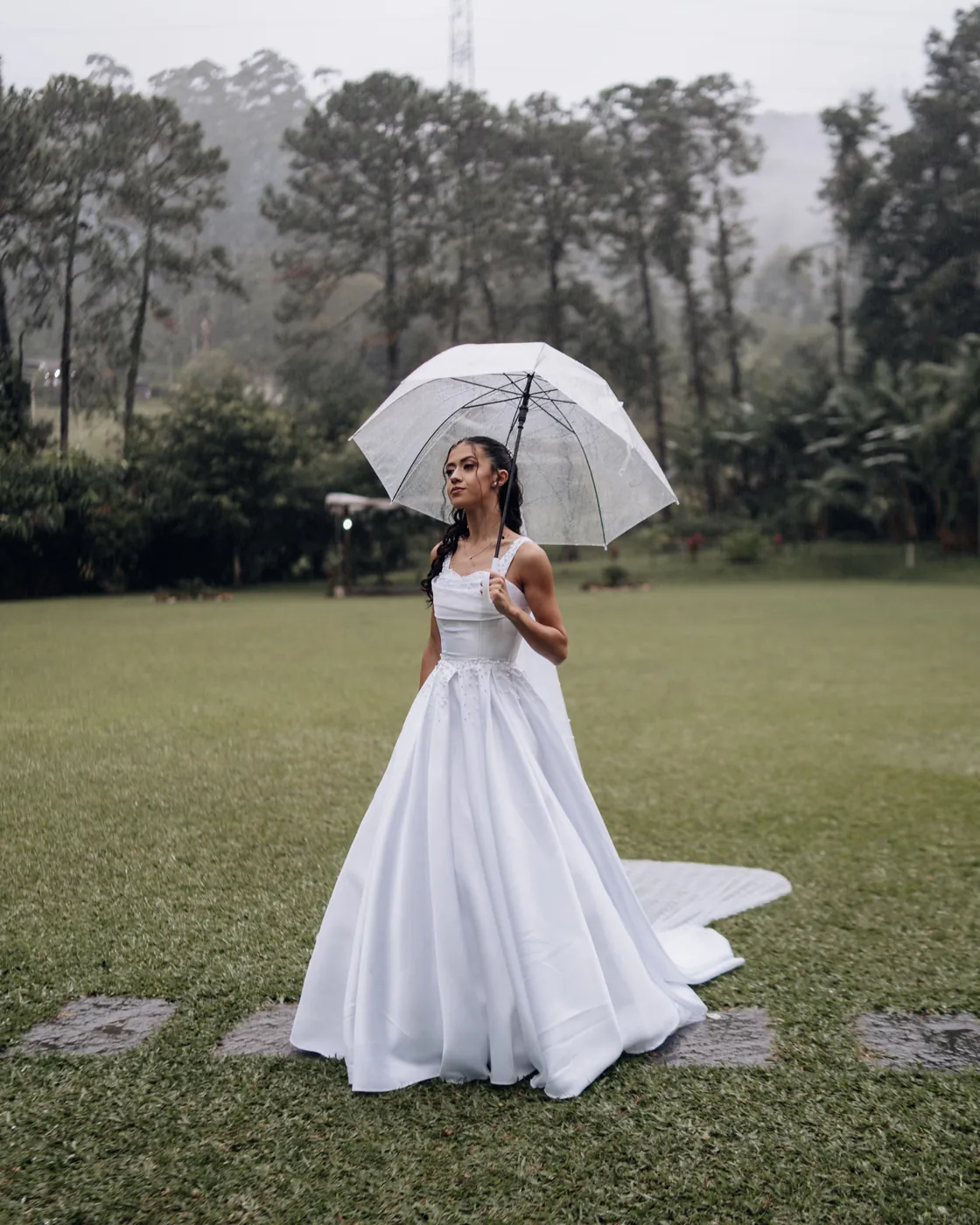 Noiva com guarda-chuva no gramado